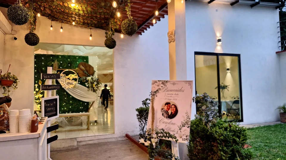 Entrada de boda con iluminación cálida y montaje de bienvenida.
