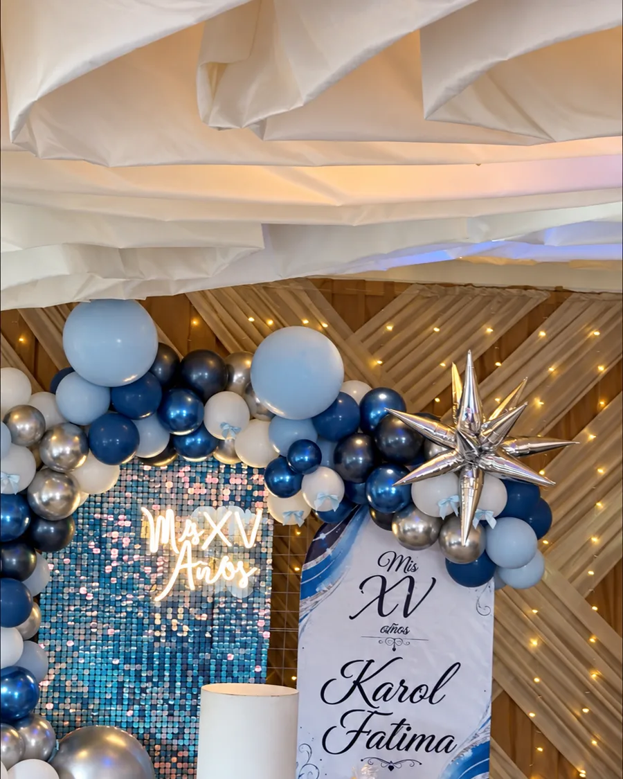 Decoración de XV años con globos azules y plateados.